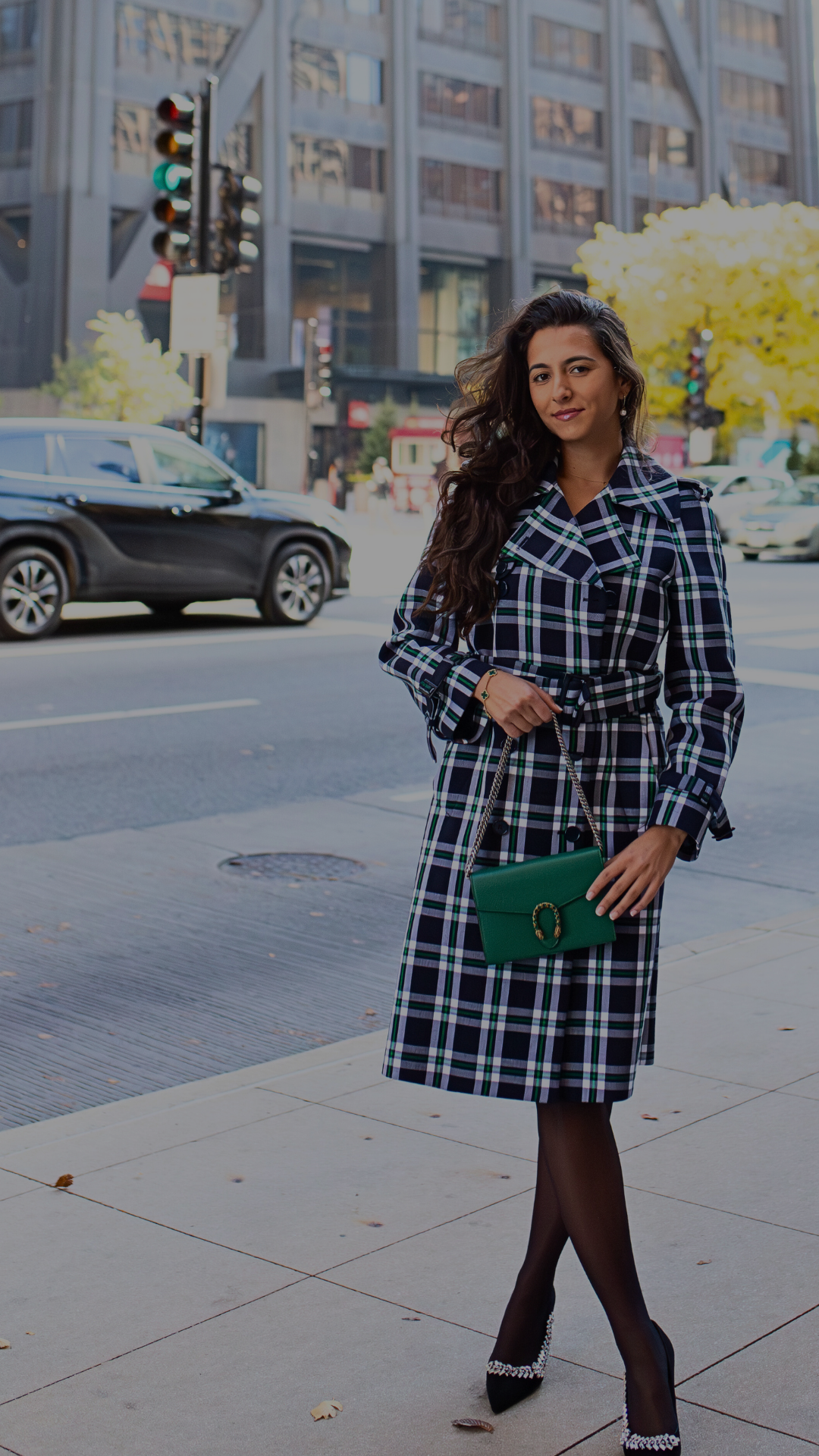 Woman in a plaid coat standing on a city street