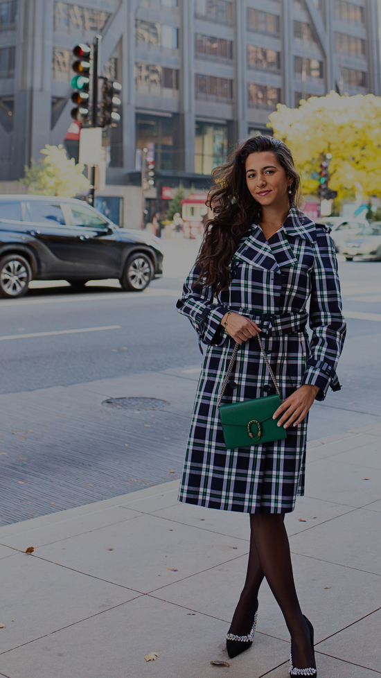 Woman in a plaid coat standing on a city street