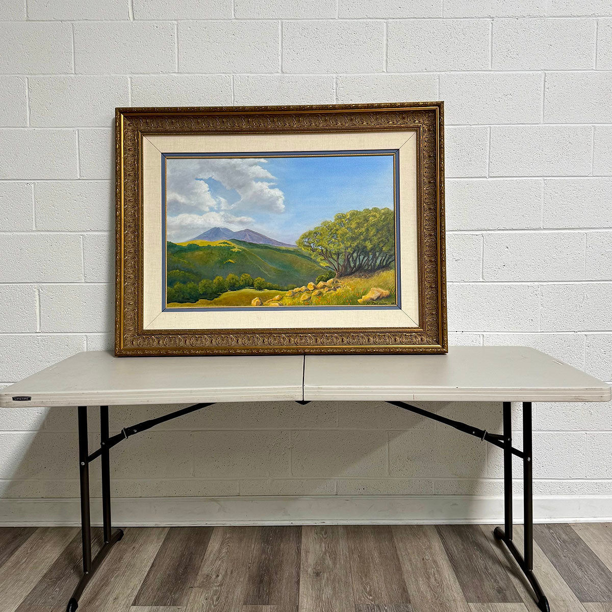 "Landscape Featuring a Meadow with Mountains in the Background" Signed
